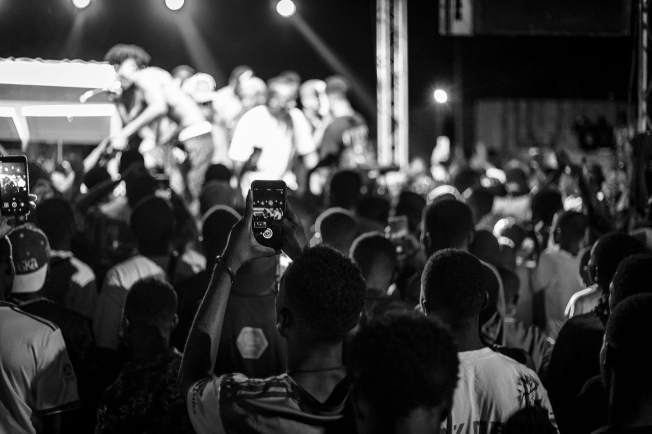 Crafting Captivating Headlines: Your awesome post title goes here Vibrant live concert with crowd and performers captured in monochrome tone.