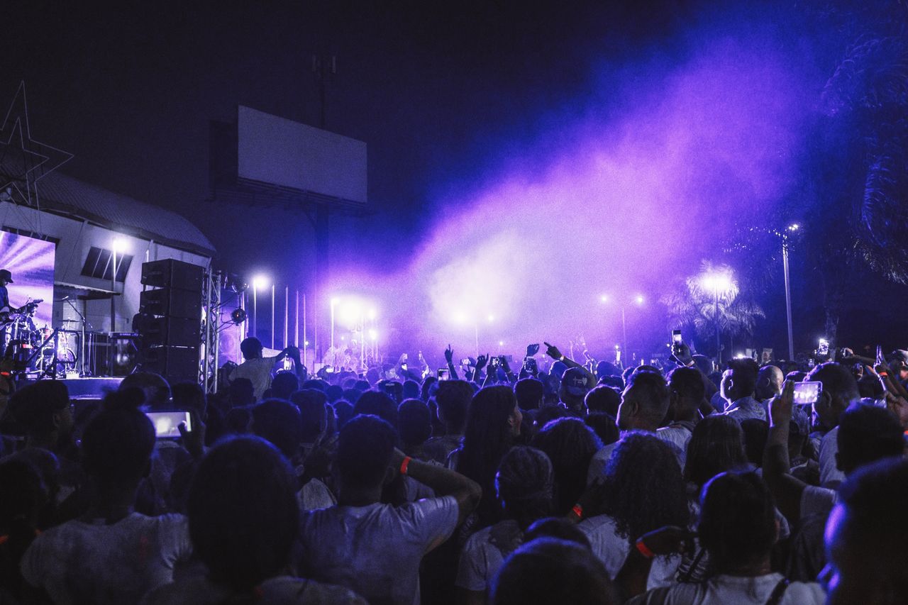 About Vibrant nighttime concert scene with colorful stage lights and a lively audience enjoying the music.